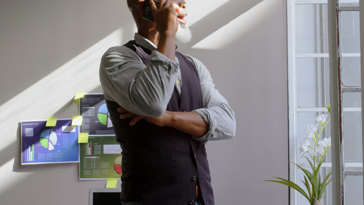 hombre de negocios hablando por teléfono móvil en la oficina 4k
