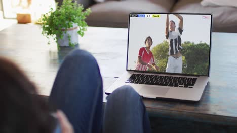 Video-Einer-Frau,-Die-Auf-Dem-Sofa-Sitzt-Und-Zu-Hause-Auf-Dem-Laptop-Fußball-Schaut