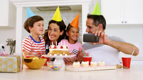 familia feliz tomando una selfie mientras celebran un cumpleaños