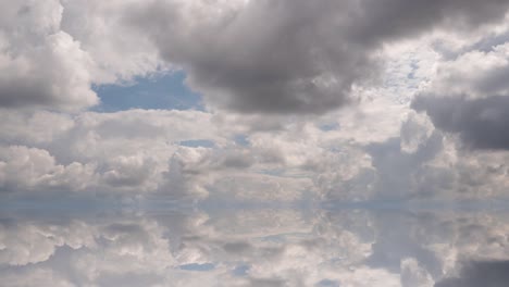 futuristic background consisting of time lapse clip of white fluffy clouds over blue sky and their reflection, video loop