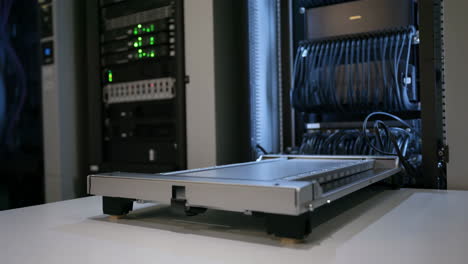 server rack with blinking lights and hardware on a table in a data center