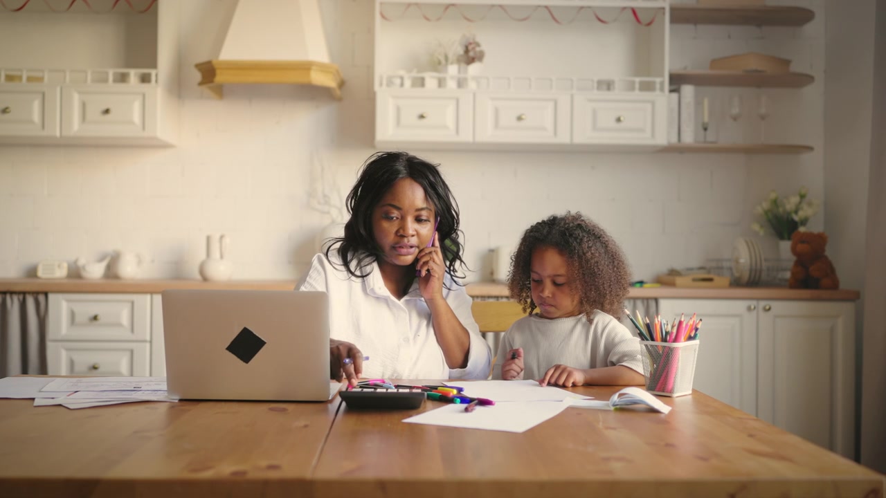 Mother Working From Home While Helping Daughter With Homework