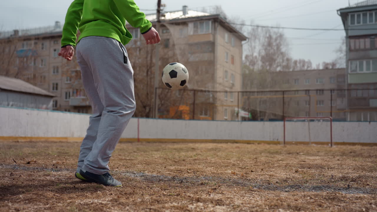 человек, выполняющий повторяющиеся удары ногами в грязи; человек, наносящий несколько ударов ногами по грязной местности в городских условиях; спортсмен, многократно ударяющий землю ногами на пропитанном дождем городском поле