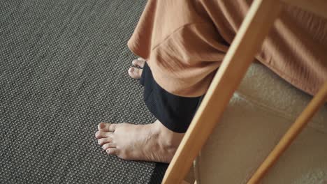 person sitting barefoot on a carpet