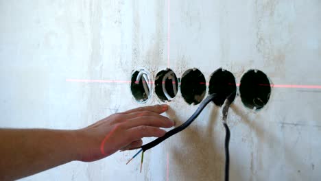 manos masculinas de primer plano comprobando los parámetros técnicos con cinta métrica y herramienta láser en el sitio de construcción