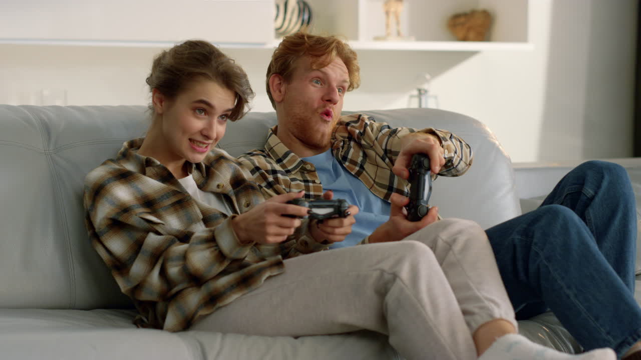 Giocatori entusiasti si godono il videogioco. Coppia felice celebra la vittoria virtuale.