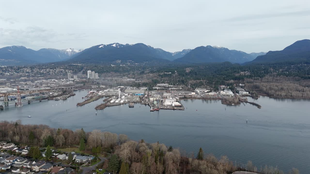 Banchina industriale lungo Burrard Inlet vicino al Ponte commemorativo degli Ironworker a North Vancouver, Canada. Ripresa aerea ampia, con allontanamento.