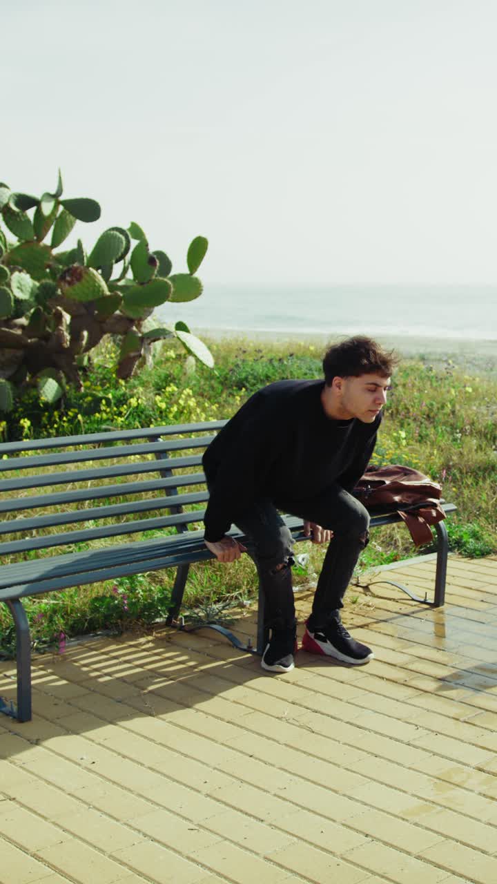 University Student Relaxing On A Bench Near The Ocean