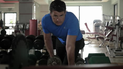 man exercising with dumbbell in the gym