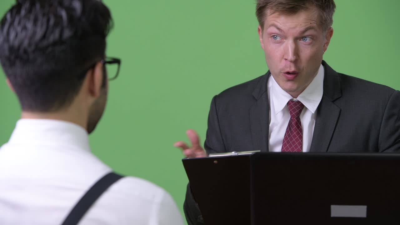 초록색 배경에서 함께 일하는 두 명의 젊은 다민족 사업가