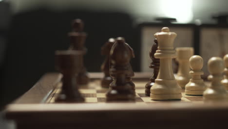 detail of movement of the white queen piece over dark pieces in a professional chess game