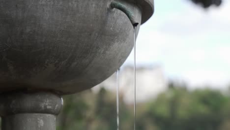 Tiro-Inclinado-Hacia-Arriba-De-Un-Estrecho-Arroyo-De-Agua-Que-Cae-De-Una-Fuente-En-Cámara-Lenta-En-Granada,-España