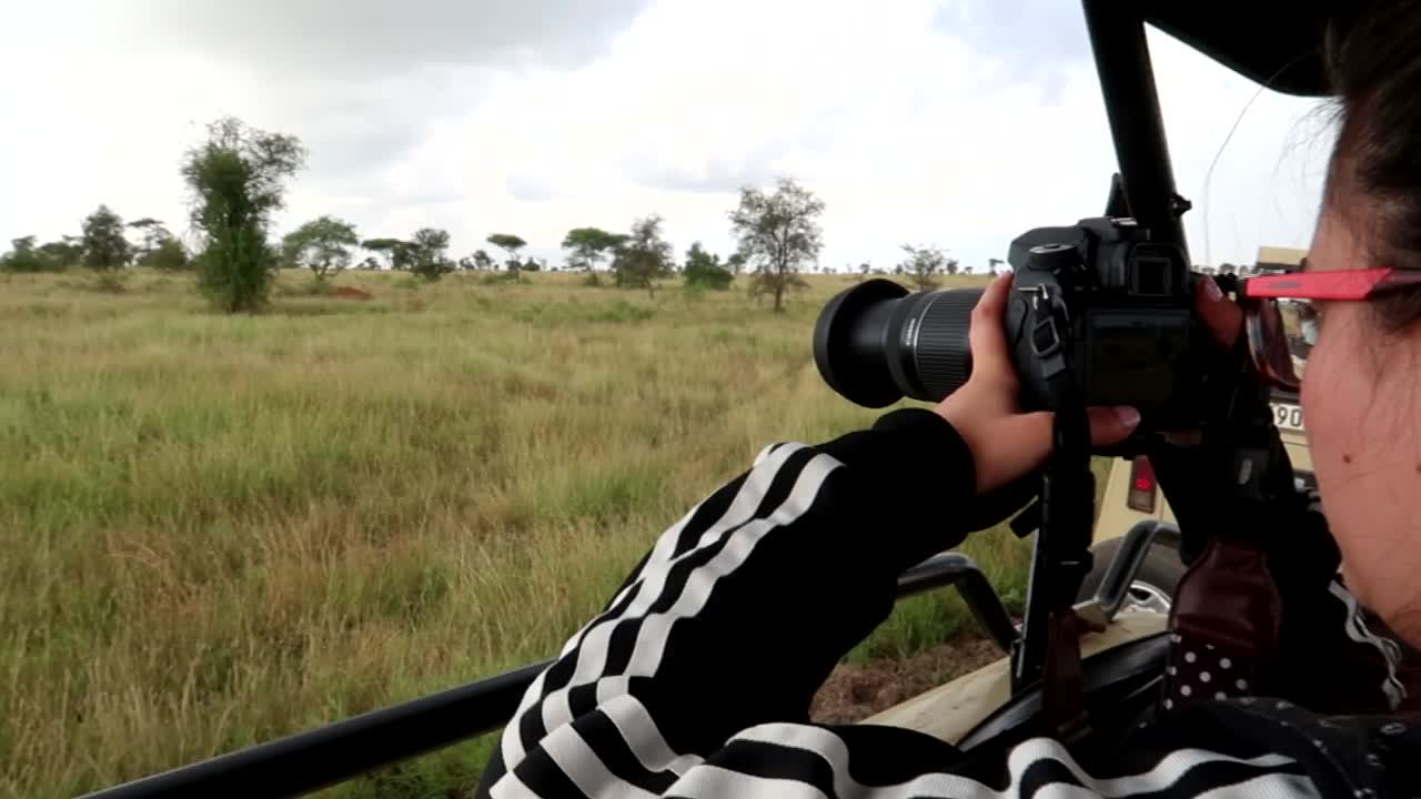 Woman using long lens camera to take pictures of wild animals