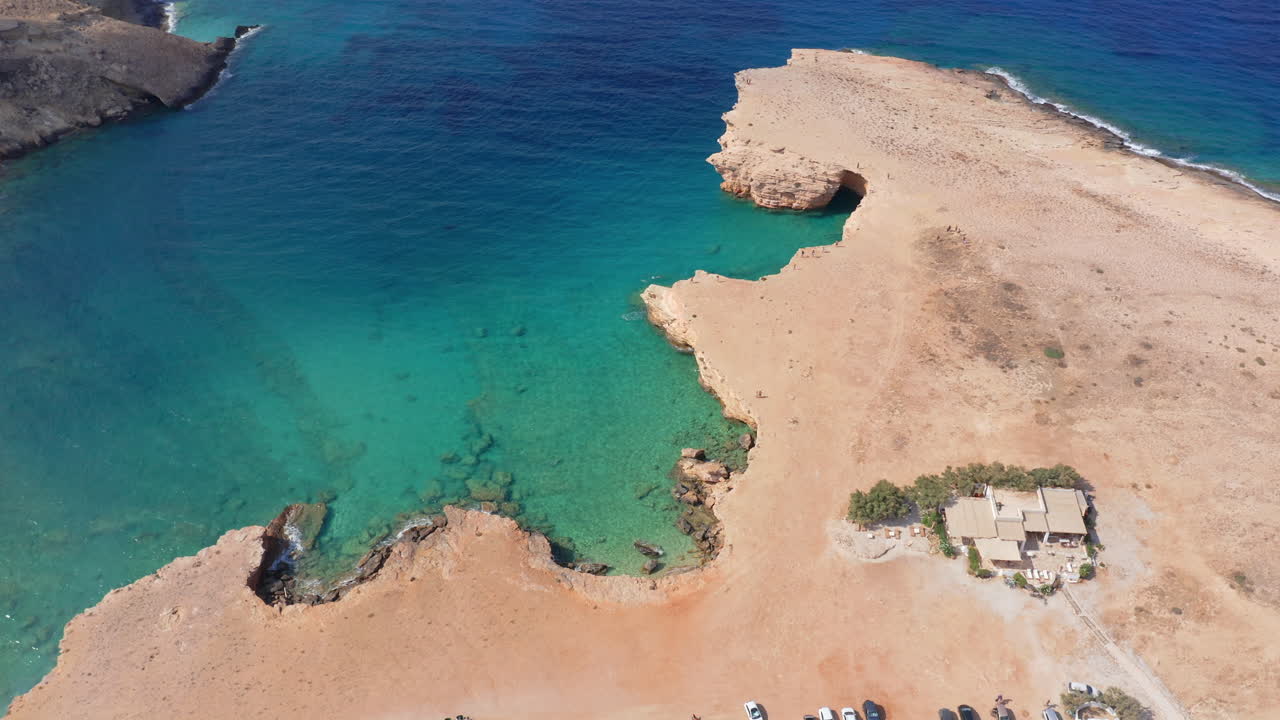 Panoramic drone shot of Ksylompatis caves near Pori beach coast on Koufonisia, Cyclades, Greece