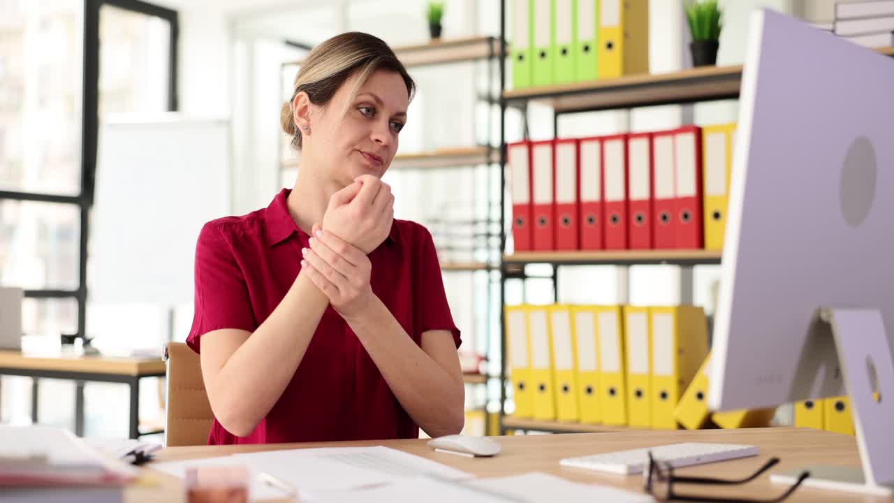 Woman Experiencing Wrist Pain While Working at Office Desk