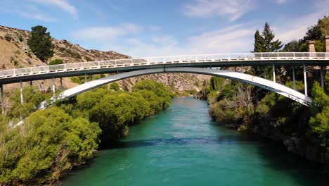 roxburgh bridge aerial drone fly under the bridge above clutha river in teviot valley, small town in central otago, new zealand