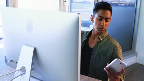 Executive-using-mobile-phone-while-working-on-computer-4k