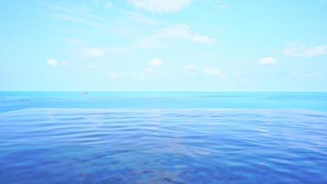 Cámara-Al-Nivel-Del-Agua-De-La-Piscina-Con-Vistas-Al-Horizonte-Del-Océano