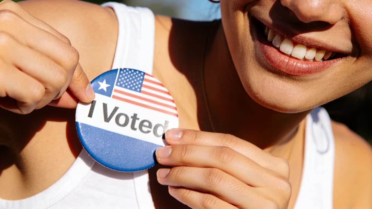 Applying voter peeling backing, pressing I Voted button onto white tank top after voting, outdoors