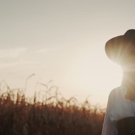 farmer in a dress and hat walks in a field of ripe corn 6