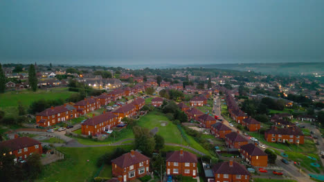 Explore-La-Famosa-Finca-Municipal-De-Dewsbury-Moore-En-El-Reino-Unido-A-Través-De-Un-Video-Capturado-Con-Drones,-Que-Muestra-Viviendas-Propiedad-Del-Ayuntamiento,-Casas-Adosadas-De-Ladrillo-Rojo-Y-El-Telón-De-Fondo-Industrial-De-Yorkshire.