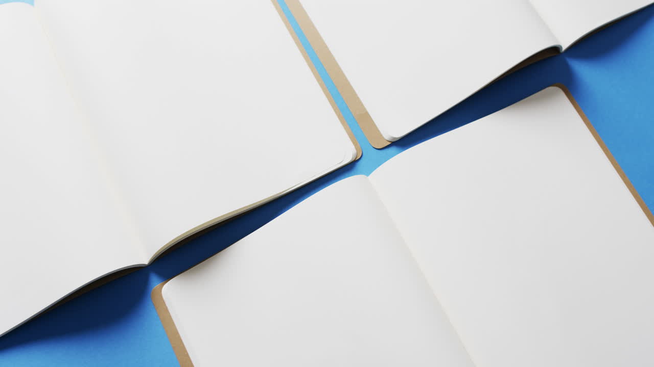 슬로우 모션으로 파란색 배경에 복사 공간을 가진 열린 빈 책의 클로즈업