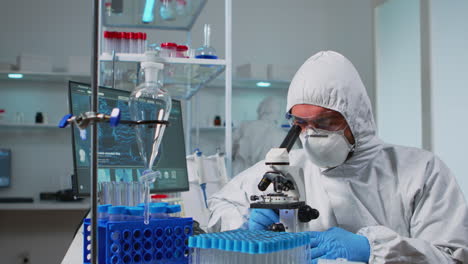 médico biólogo en ropa de camiseta comprobando la muestra de adn usando el microscopio