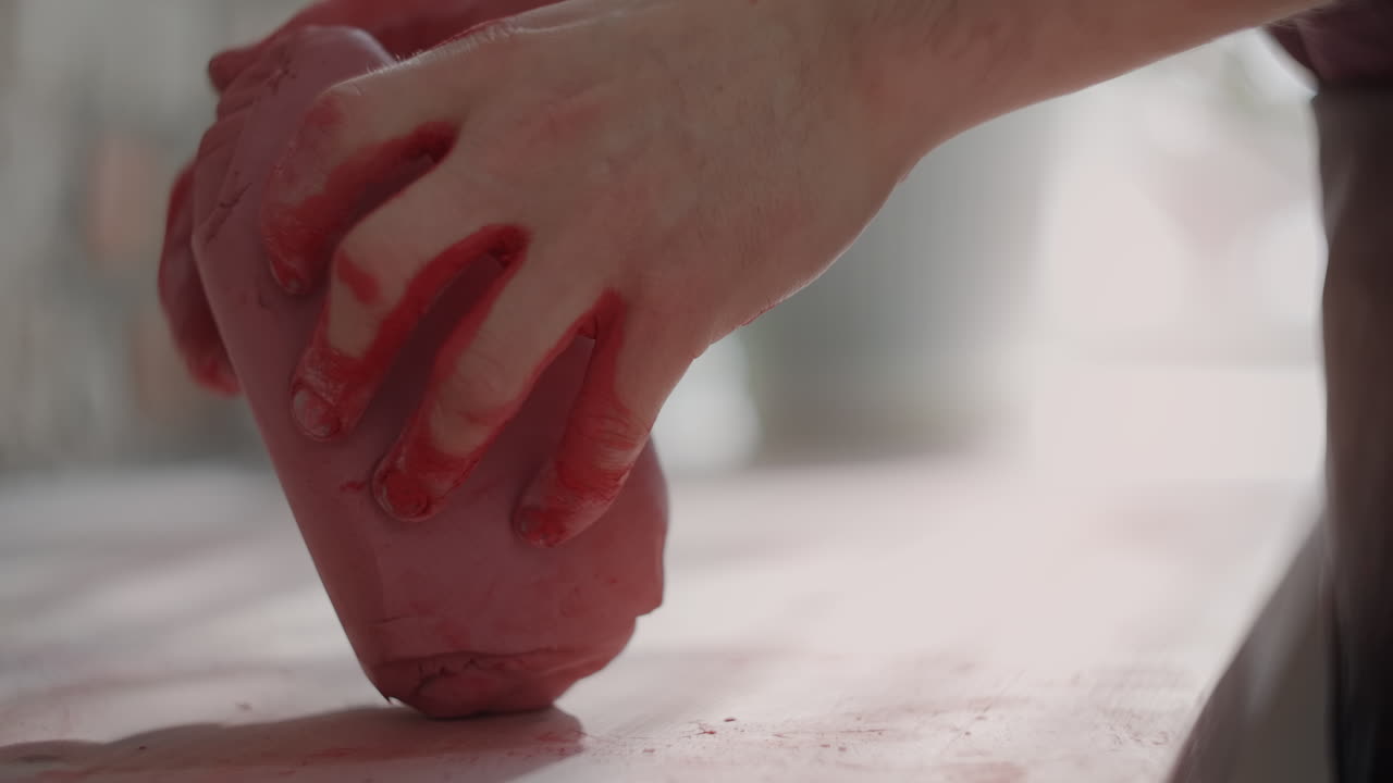 Hands Shaping Red Clay