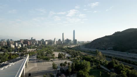 Drohnenaufnahme-Der-Gemeinde-Vitacura-Und-Der-Hauptstraße-Von-Santiago-De-Chile-Mit-Dem-Finanzviertel-Am-Horizont---Luftaufnahme