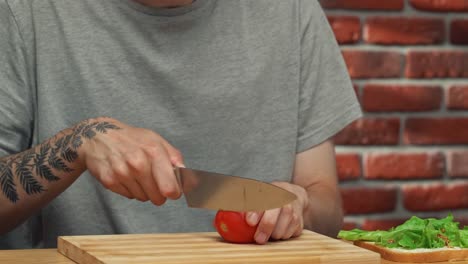 preparando un sándwich con un tomate