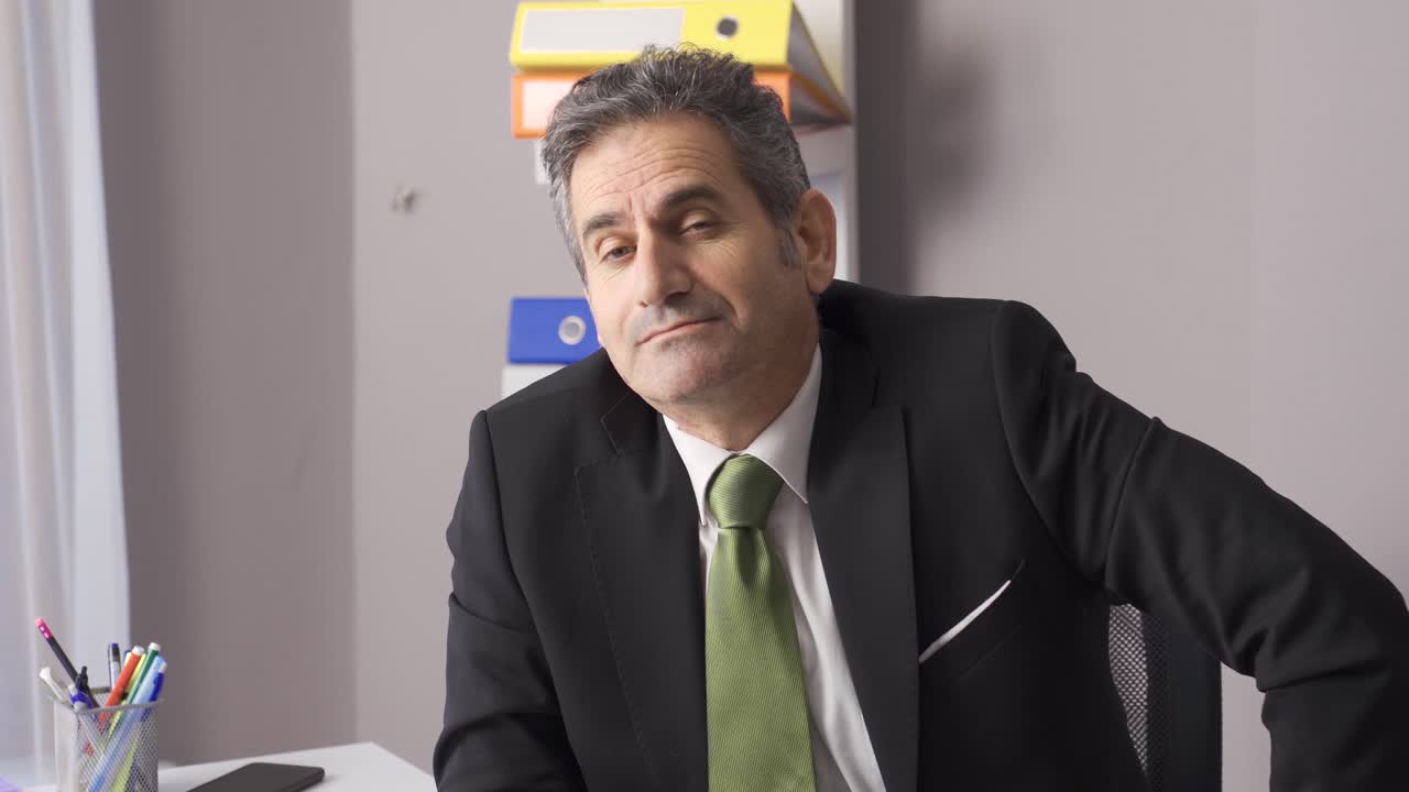 un hábil y arrogante hombre de negocios mirando a la cámara.