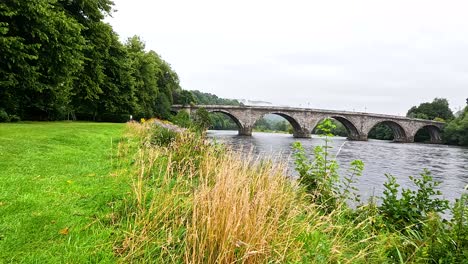 peaceful river scene with bridge and greenery