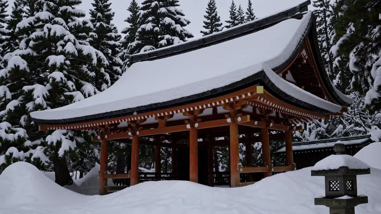 A serene winter scene with snow-covered trees and a traditional structure