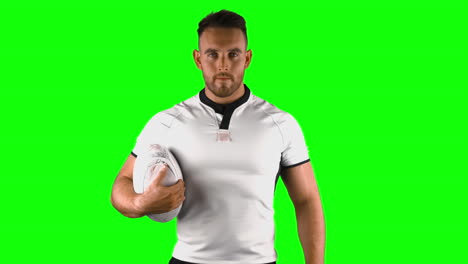 serious rugby player holds rugby ball