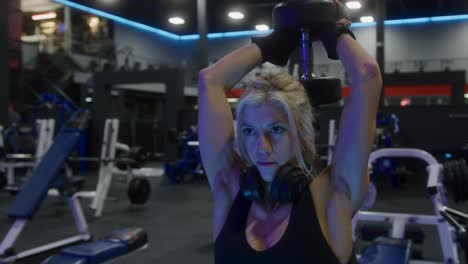 Slow-motion-shot-of-an-athletic-girl-doing-an-overhead-triceps-extension-with-a-dumbbell