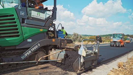 modern machinery for laying fresh asphalt. roadworks on a highway. paver machines pressuring hot asphalt on the road. road construction works.