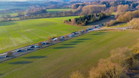 Aerial-View-of-a-Country-Road-Winding-through-Vibrant-Green-Fields