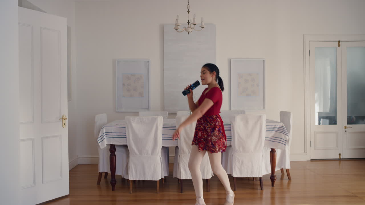 una adolescente bailando cantando karaoke con confianza celebrando un fin de semana despreocupado disfrutando de movimientos de baile tontos divirtiéndose en casa 4k