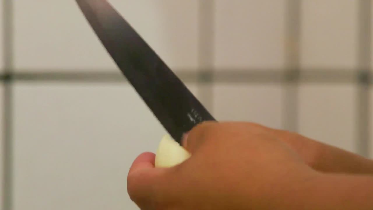 여자가 요리하는 동안 칼로 양파를 잘라