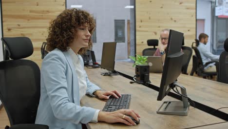 mujer trabajando en una computadora en una oficina