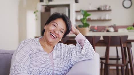 Portrait-of-african-american-senior-woman-smiling-sitting-on-the-couch-at-home