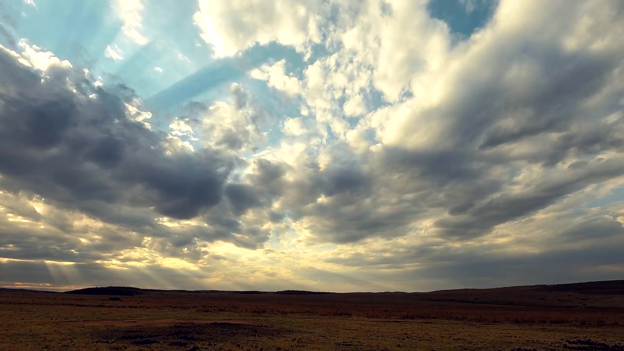 Timelapse of sunset behind storm clouds over Africa's dramatic, dark landscape