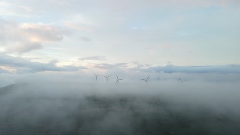 wind turbines on mountains, generate green energy, surrounded by clouds in the sky