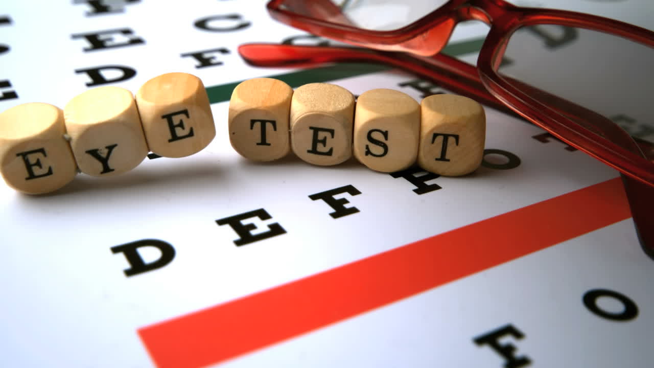 los dados de prueba ocular que caen en la prueba ocular junto a las gafas de lectura rojas