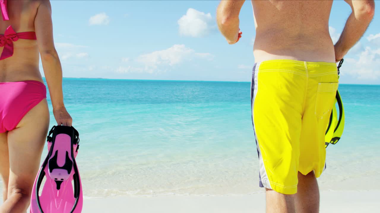 스노클링 장비 를 들고 카리브 해변 에 있는 백인 부부