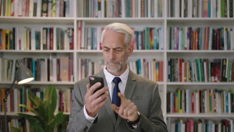 Retrato-De-Un-Hombre-De-Negocios-Profesional-Usando-Un-Teléfono-Inteligente-En-La-Oficina-De-La-Biblioteca-Un-Caballero-Sonriente-Arquitecto-Profesor-Conferenciante