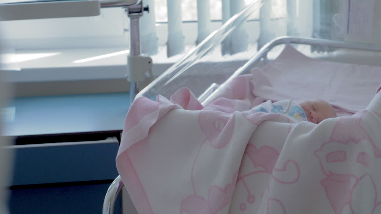 Neonata che dorme durante i suoi primi giorni in ospedale di maternità