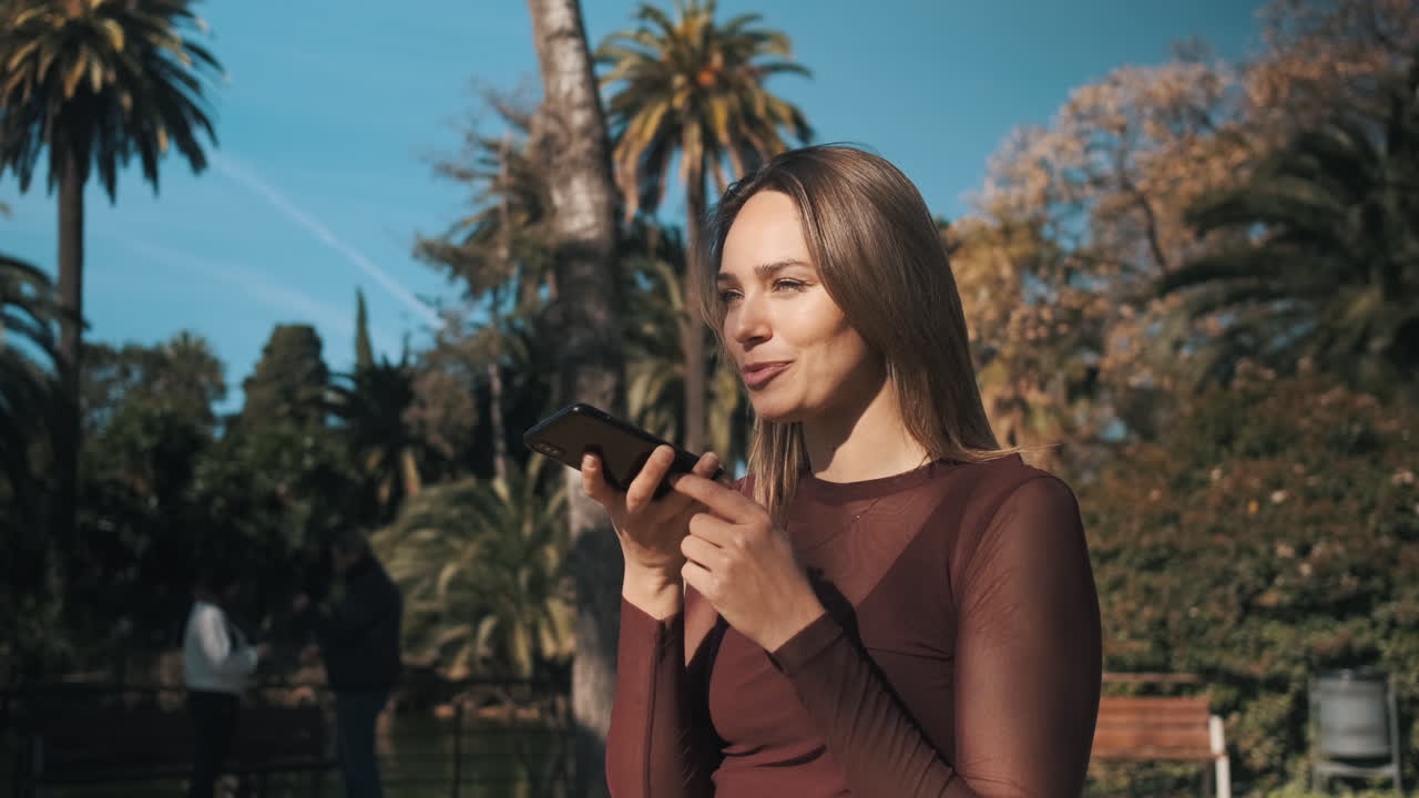 una mujer joven usando un teléfono inteligente al aire libre.