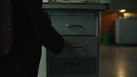person opening drawers at a vintage office desk