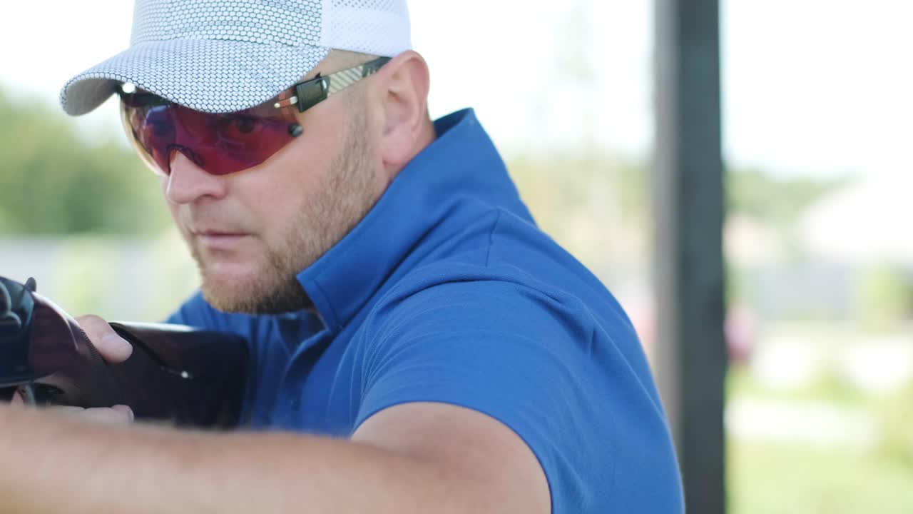 스포츠맨이 이중 배럴 건으로 총을 고, 슈팅 테스트를 위한 스포츠 경기장은 날아다니는 스케이트를 고 있습니다.